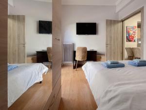 雅典2-bedroom Winter Apartment的酒店客房配有两张床和一张书桌