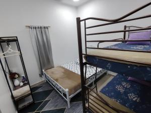 浮罗山背Sri MaLati Homestay and Event Space的宿舍间设有两张双层床和梯子。