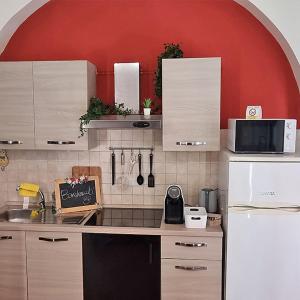 利沃诺Casa Fortunata con parcheggio的厨房配有白色橱柜和红色墙壁