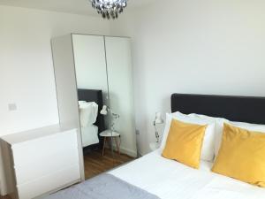 曼彻斯特Media City Salford Quays的一间卧室配有镜子和一张带黄色枕头的床