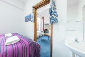 伦敦Pax Lodge的一间卧室配有床、水槽和镜子