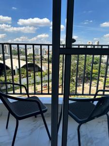 圣保罗Apartamento novo decorado com sacada e linda vista da Cidade的市景阳台配有两把椅子