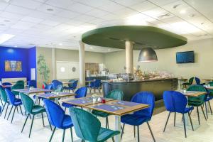 罗兹钟楼罗兹酒店的一间设有蓝色桌椅的餐厅和一间酒吧