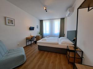 布拉格来吉酒店的一间卧室配有一张床、一把椅子和镜子