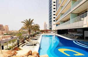 迪拜Sea-View 2Bedroom plus Sofa Bed - Near JBR Beach - HEI的一座带椅子的游泳池以及一座建筑