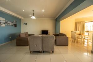 乌旺戈海滩Saints View Resort Unit 24的带沙发、电视和桌子的客厅