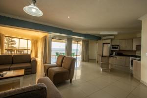 乌旺戈海滩Saints View Resort Unit 24的带沙发和椅子的客厅以及厨房。