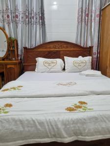槟知Khách Sạn Trường Thịnh的一张带两个白色枕头的床,上面有心
