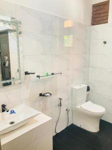 阿努拉德普勒Yatinuwara Bungalow的白色的浴室设有卫生间和水槽。