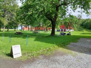 AlstahaugTjøtta Gjestegaard的草上有树和标志的公园