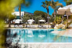 乌贾诺拉基耶萨Borgo Mulino a Vento - Resort的度假村的游泳池,配有椅子和遮阳伞