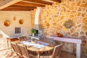 坎波斯Marina Ses Covetes的一间设有桌子和石墙的用餐室