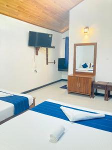 阿努拉德普勒Yatinuwara Bungalow的酒店客房,设有两张床和镜子