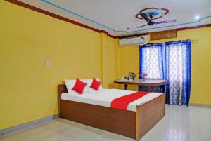 瓦拉纳西Goroomgo Sanskriti Paying Guest House Varanasi - Excellent Customer Choice- Best Seller的一间卧室配有一张黄色墙壁的床和一张桌子