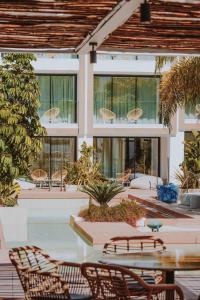 圣埃乌拉利亚Nativo Hotel Ibiza的一个带桌椅的庭院和一座建筑