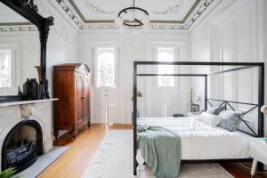 卡温顿Decadent Luxury - Covington Condo的一间白色卧室,配有一张床和一个壁炉