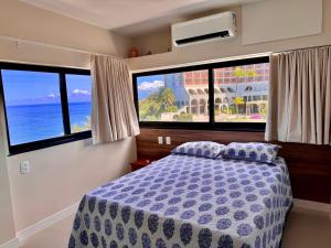 萨尔瓦多Ondina Apart Hotel Residences的一间卧室设有一张床和两个大窗户