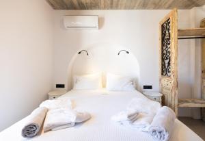 罗德镇Casa del Sol Suites的卧室配有白色床和毛巾
