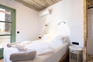 罗德镇Casa del Sol Suites的卧室配有白色床和毛巾