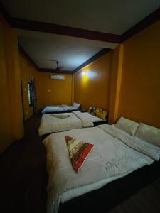 索拉哈Busy Bee Guest House的客房设有三张床、白色床单和枕头