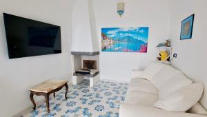 康加德马里尼Relais Amalfi Coast的客厅配有白色沙发和壁炉
