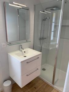 DameryLe Claugi的浴室配有白色水槽和淋浴。