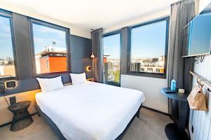 巴黎巴黎布洛涅16号宜必思尚品酒店的酒店客房设有一张床和大窗户