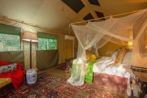 玛洛斯帕克Wielewaal Bush Lodge的一间帐篷内带天蓬床的卧室