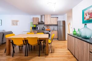 阿林萨尔Apartamento TINTIN en Arinsal的厨房配有木桌和黄色椅子