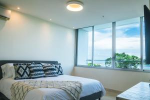 普拉亚伯尼塔村Oceanview Apt Near Panama City w/ King Bed & More的一间卧室设有一张床和一个大窗户