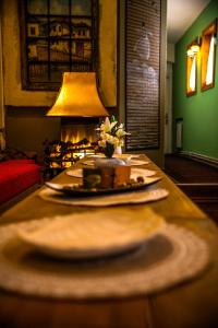 萨拉热窝Guesthouse Yildiz 2的客厅里一张桌子,上面有盘子和台灯