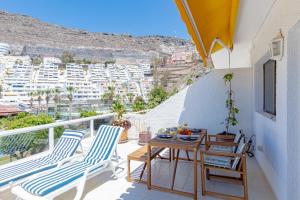 圣地亚哥港Cliff View Terrace by Dream Homes Tenerife的阳台配有桌椅,享有城市美景。