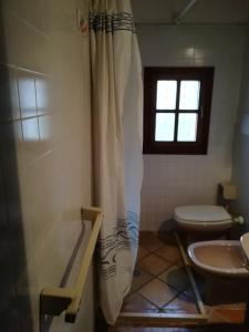 卡沃马里尼奥公寓的带淋浴和卫生间的浴室以及窗户。