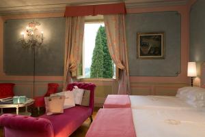 菲利内瓦尔达诺Villa la Borghetta Spa Resort的一间卧室配有一张床、一张沙发和一个窗口
