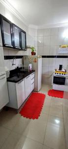库亚巴Apto aconchegante cuiaba的带冰箱和红色地毯的厨房
