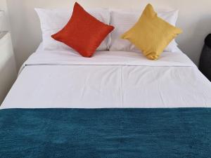 伦敦Immaculate 2-Bed Apartment in London的一张白色的床,上面有三个色彩缤纷的枕头