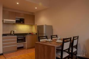圣马丁德洛斯Departamentos - Belgrano 810的厨房配有桌椅和冰箱。