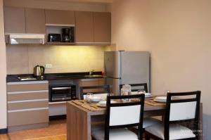 圣马丁德洛斯Departamentos - Belgrano 810的厨房配有桌椅和冰箱。