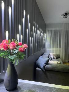 维也纳Green Park Apartment的客厅里设有花瓶,里面装有粉红色的花朵