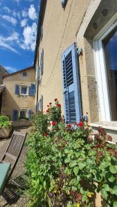 Anchenoncourt-et-ChazelLa Grange Des Roches Roses的一座带一扇窗户的建筑,花丛