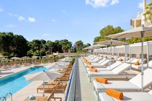 卡拉马奎达VIVA Cala Mesquida Suites & Spa Adults Only 16的度假村的游泳池配有躺椅和遮阳伞