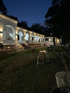 Villa Los AromosLa Posta del Jesuita的一座晚上配有桌椅的建筑
