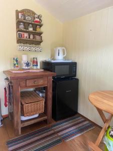 Praze an BeebleTyluna Cornish Cabin的带微波炉和桌子的小厨房