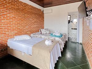 卡纳内亚Pousada Maravista的砖墙客房的两张床