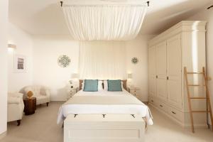 乌贾诺拉基耶萨Borgo Mulino a Vento - Resort的白色卧室配有一张带蓝色枕头的大床