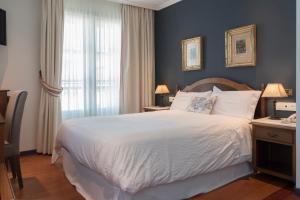 阿瓜尔达圣贝尼托修道院酒店的卧室设有一张白色大床和一扇窗户。