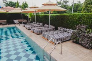 阿布贾BON Hotel Imperial的游泳池旁的一排躺椅