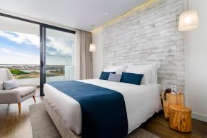 波尔蒂芒Jupiter Marina Hotel - Couples & Spa的一间卧室设有一张大床和一个大窗户