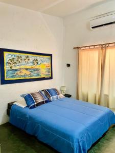 El YaqueHotel The Winds Of Margarita的卧室配有一张蓝色的床,墙上挂着一幅画