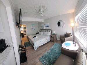 基蒂霍克海滩Saltaire Cottages的一间卧室配有一张床、一张沙发和一张桌子
